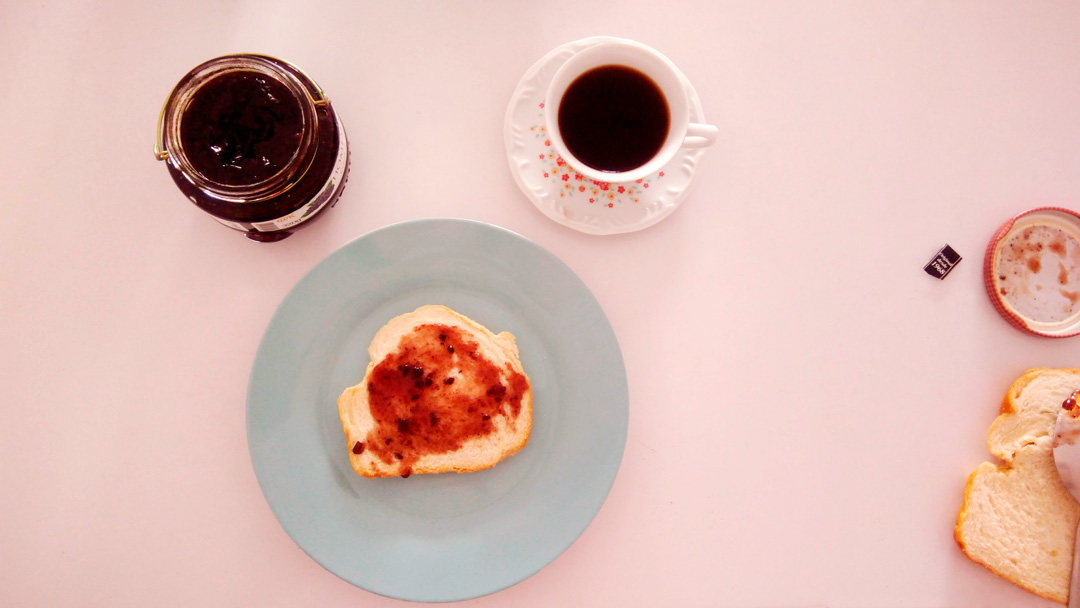Café da manhã com café, torrada com geleia e um pote de geleia aberto